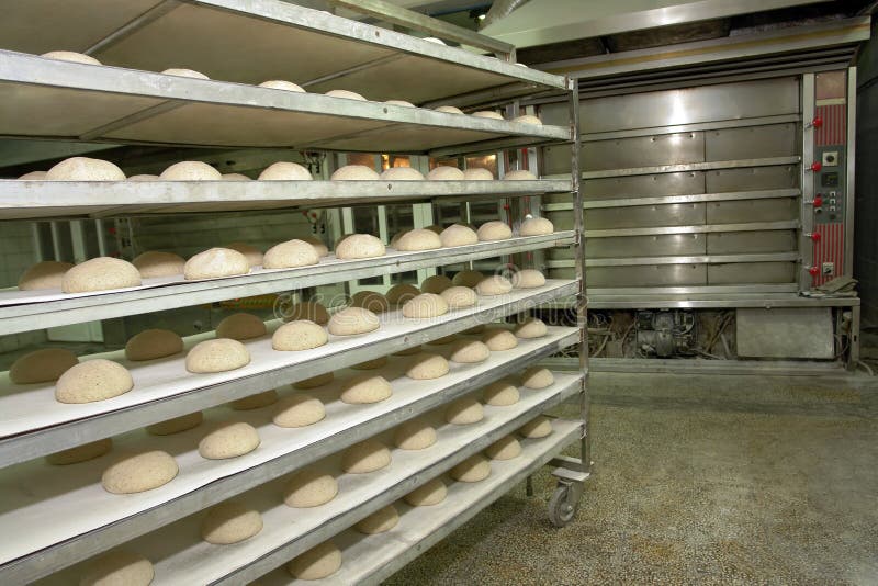 Wired rack filled with fresh uncooked bread prepared for stacking into the bakery oven.