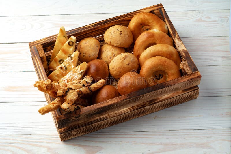 Bakery Products in Straw Bread Basket on Wooden Table Stock Photo