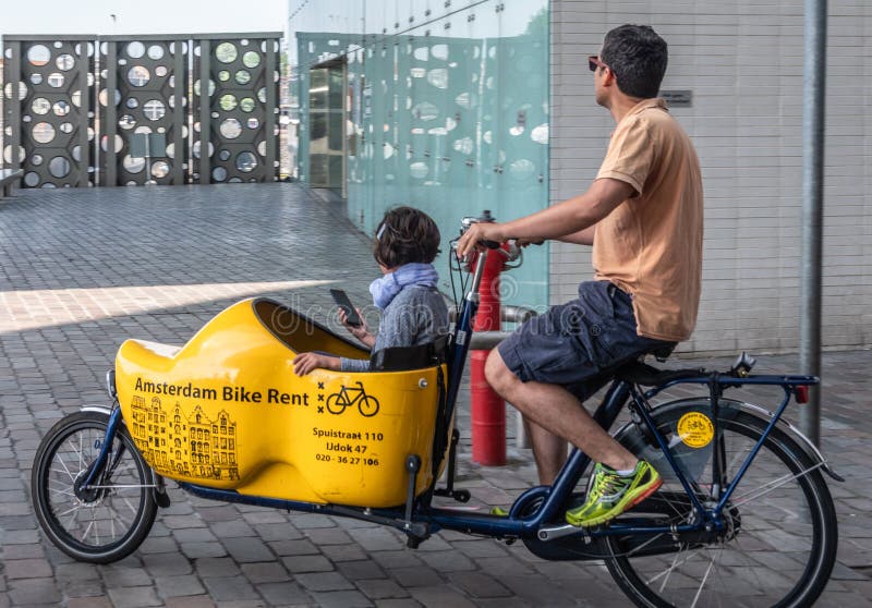 Bakfiet o bicicletta anteriore-trunk in movimento ad Amsterdam Olanda immagini stock libere da diritti Bakfiet o bicicletta anteriore-trunk in movimento ad Amsterdam Olanda immagini stock libere da diritti