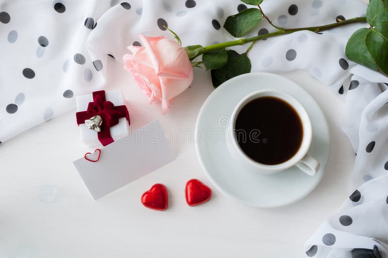 Bakgrund för St-valentindag - kopp kaffe, persikaros, tomt förälskelsekort, hjärtaformgodisar och ask för juvelgåva arkivfoto Bakgrund för St-valentindag - kopp kaffe, persikaros, tomt förälskelsekort, hjärtaformgodisar och ask för juvelgåva arkivfoto