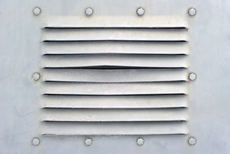 Bakgrund i den militära stilen: ett avsnitt av en grått vägg för metallight eller skal av någon pansarbil med bultar och ventilat arkivbild Bakgrund i den militära stilen: ett avsnitt av en grått vägg för metallight eller skal av någon pansarbil med bultar och ventilat arkivbild