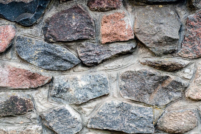 Bakgrund i form av ett fragment av en stenvägg med texturerade stenar från ett färgat rubel royaltyfria bilder