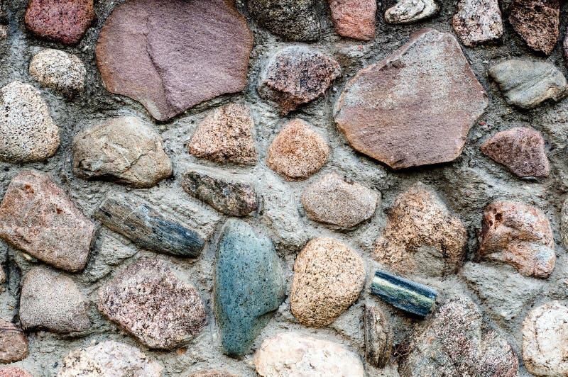 Bakgrund i form av ett fragment av en stenvägg med texturerade stenar från ett färgat rubel fotografering för bildbyråer