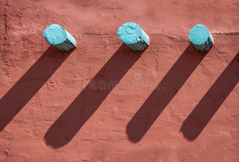 Background - Turquoise corbels and their long shadows on an orange stucco wall on southwestern style building. Background - Turquoise corbels and their long shadows on an orange stucco wall on southwestern style building.