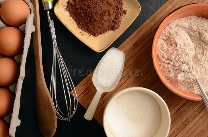 Baking ingredients on a stone table: eggs, flour, sugar and cacao royalty free stock photos Baking ingredients on a stone table: eggs, flour, sugar and cacao royalty free stock photos