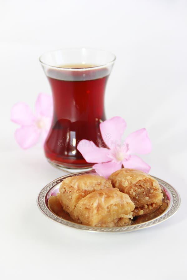 Baklava turca nazionale tradizionale di dolcezza sul piatto decorativo e su un vetro di tè fotografia stock libera da diritti Baklava turca nazionale tradizionale di dolcezza sul piatto decorativo e su un vetro di tè fotografia stock libera da diritti