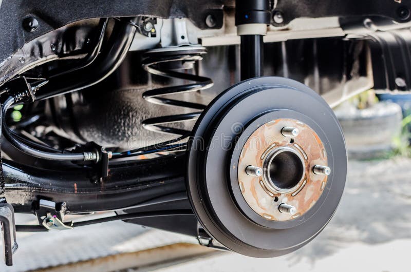 Rear brake on car in process of new tire replacement. The rim is removed showing the rotor. Rear brake on car in process of new tire replacement. The rim is removed showing the rotor