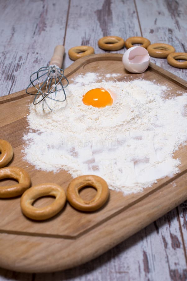 Bakselconcept Bestrooide bloem en eieren op houten scherpe raad, kokende ingrediënten Tref voor het maken van gistdeeg voorbereid stock foto Bakselconcept Bestrooide bloem en eieren op houten scherpe raad, kokende ingrediënten Tref voor het maken van gistdeeg voorbereid stock foto