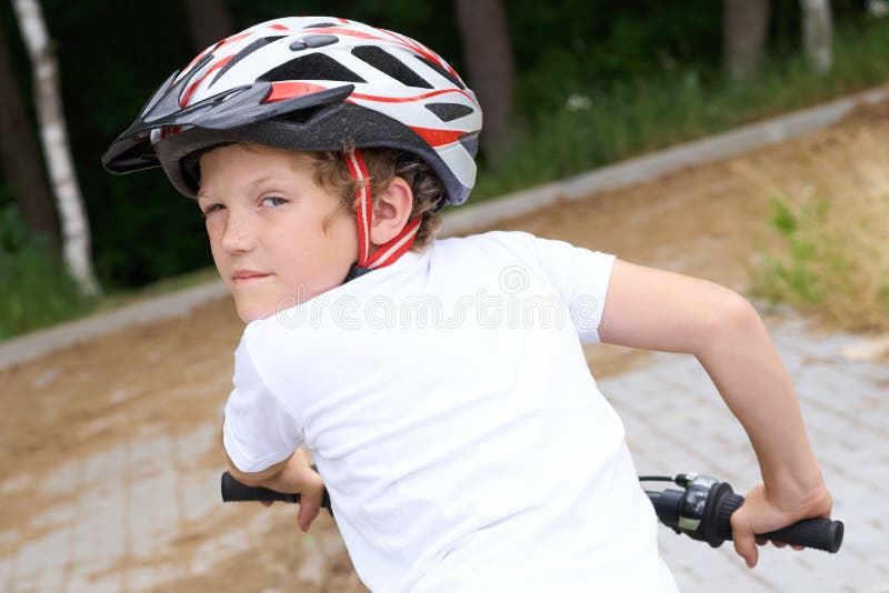 Baksida av småpojken i en hjälmcykelcykel i parken på sommardagen Veckoaktivitet arkivfoto