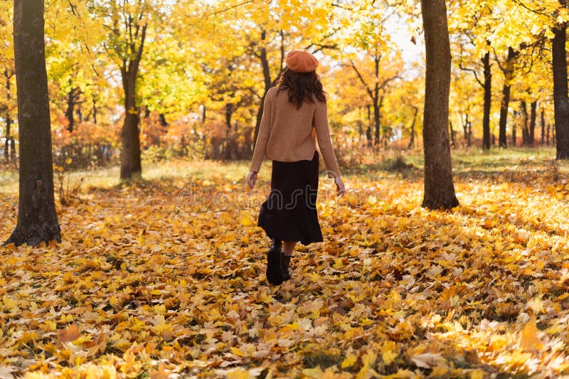Baksida av unga kvinnor på hösten som går i guldstadsparken. höstpromenad royaltyfri foto