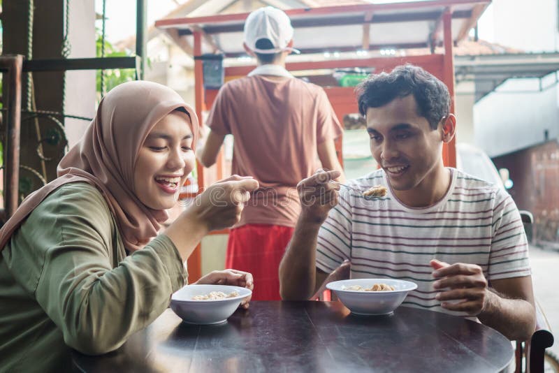 Bakso. indonesian famous meatball street food. asian woman and man enjoy eating bakso. Bakso. indonesian famous meatball street food. asian woman and man enjoy eating bakso