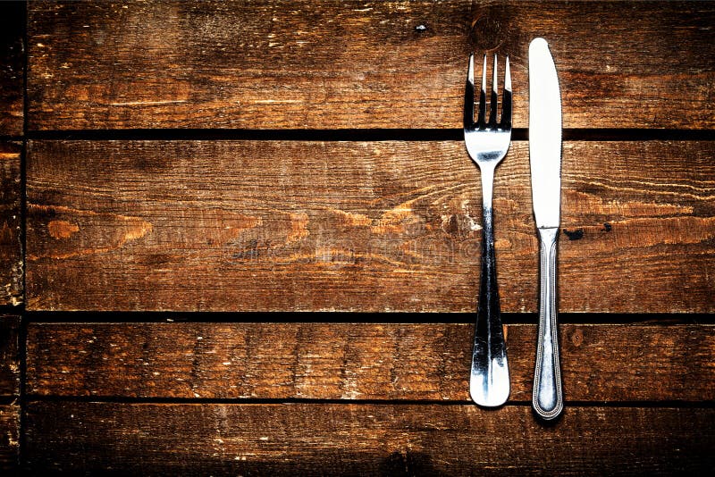 Silver Knife and fork over wooden table with copy space. Diet Food concept. Silver Knife and fork over wooden table with copy space. Diet Food concept.