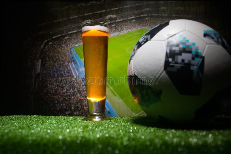 BAKU,AZERBAIJAN - JUNE 23, 2018 : Official Russia 2018 World Cup football ball The Adidas Telstar 18 and single beer glass on gras