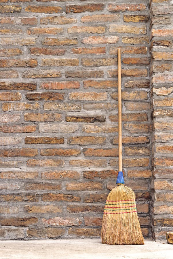 Household Used Broom For Floor Dust Cleaning Leaning on Brick Wall. Household Used Broom For Floor Dust Cleaning Leaning on Brick Wall