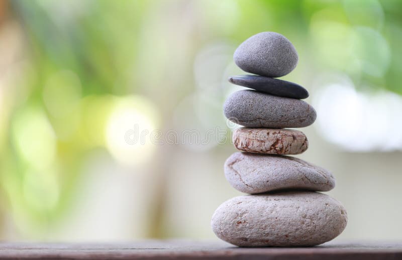 Balance Stones stacked to pyramid in the soft green background.