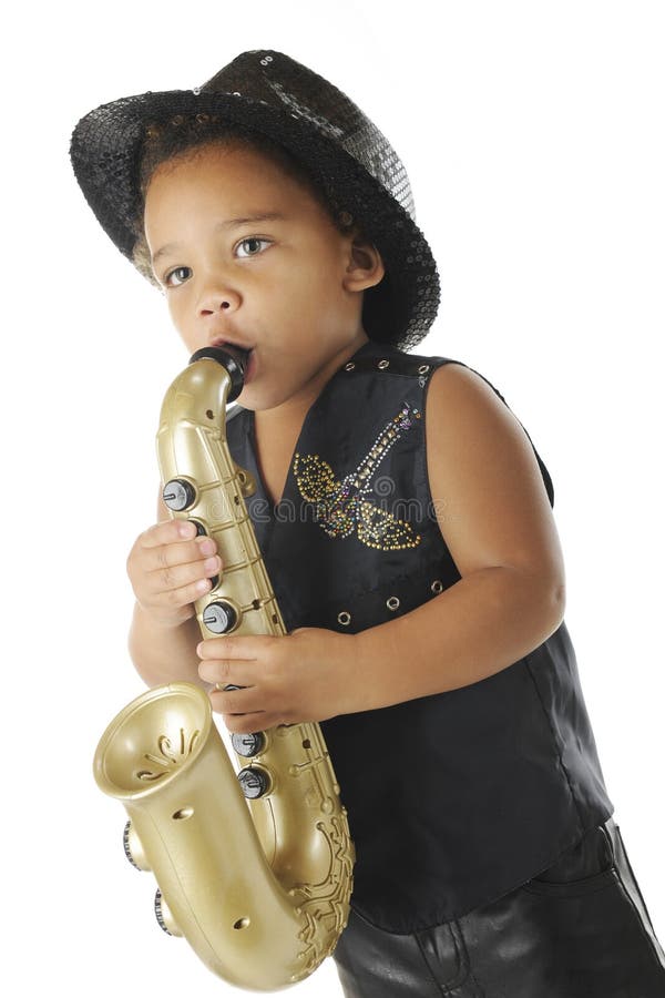 An adorable preschooler playing a toy saxophone in a sparkly black fedora and balck leather vest and pants. On a white background. An adorable preschooler playing a toy saxophone in a sparkly black fedora and balck leather vest and pants. On a white background.