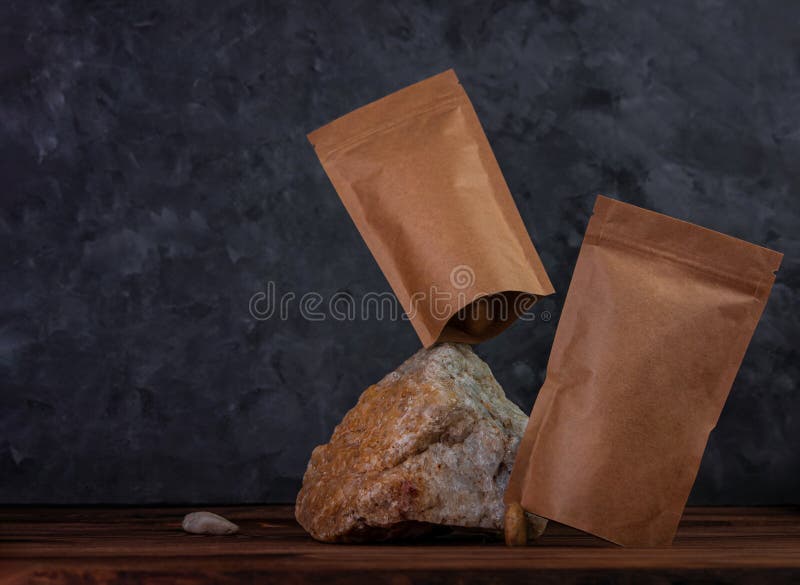 Balanseringspåse, mockup naturlig sten. Blankt kraftpappersförpackning med kaffebönor, mörk bakgrund. flytande jämvikt royaltyfria foton