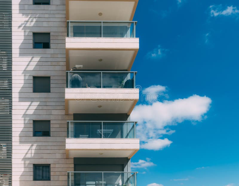 Balconies and blue sky with clouds. Part of a residential building in Israel.