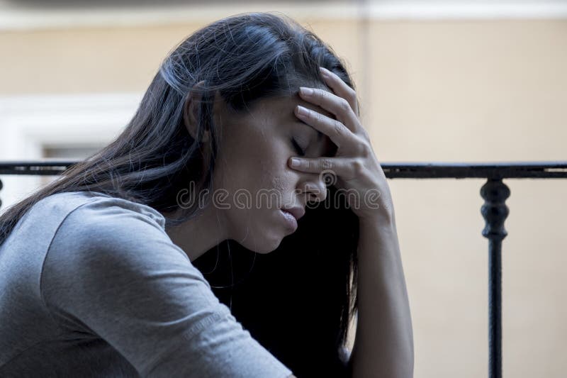 Balcão latino triste desesperado da mulher em casa que olha depressão de sofrimento devastado e deprimida fotos de stock Balcão latino triste desesperado da mulher em casa que olha depressão de sofrimento devastado e deprimida fotos de stock