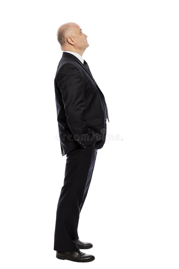 Bald middle-aged man in a suit looks up, full-length, side view. Isolated on white background. Vertical royalty free stock images Bald middle-aged man in a suit looks up, full-length, side view. Isolated on white background. Vertical royalty free stock images