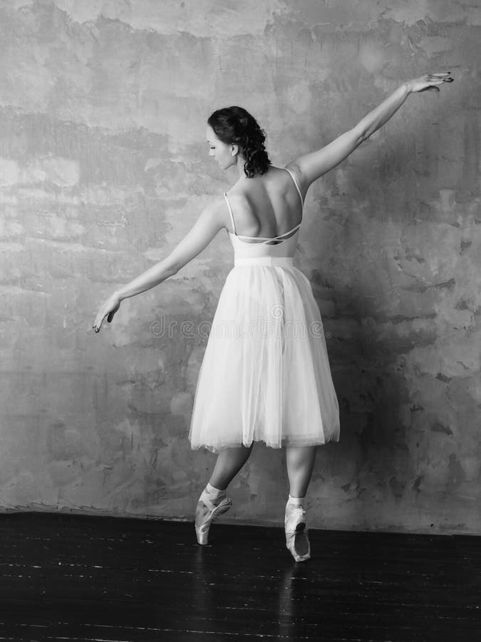Ballet dancer ballerina in beautiful light white dress tutu skirt posing in loft studio. Ballet dancer ballerina in beautiful light white dress tutu skirt posing in loft studio