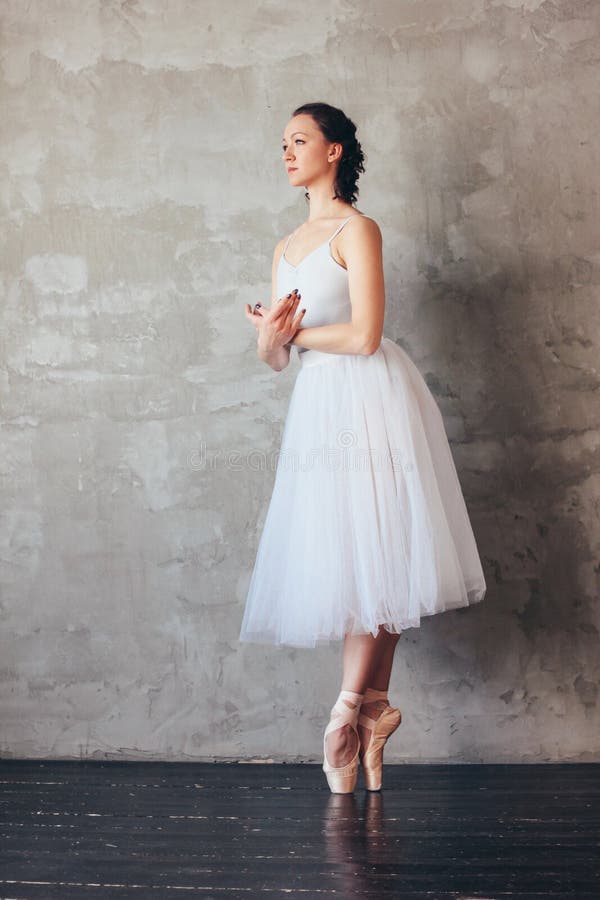 The Ballet dancer ballerina in beautiful light blue dress tutu skirt posing in loft studio. The Ballet dancer ballerina in beautiful light blue dress tutu skirt posing in loft studio