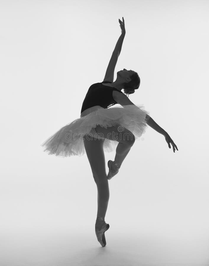 A ballet dancer in a ballet tutu and pointe shoes on a white background. A ballet dancer in a ballet tutu and pointe shoes on a white background