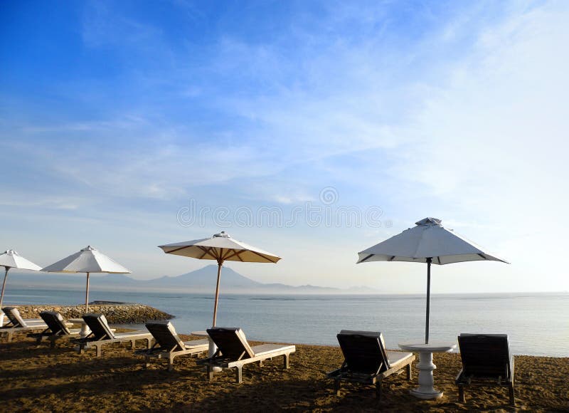 Bali beach resort scene with loungers