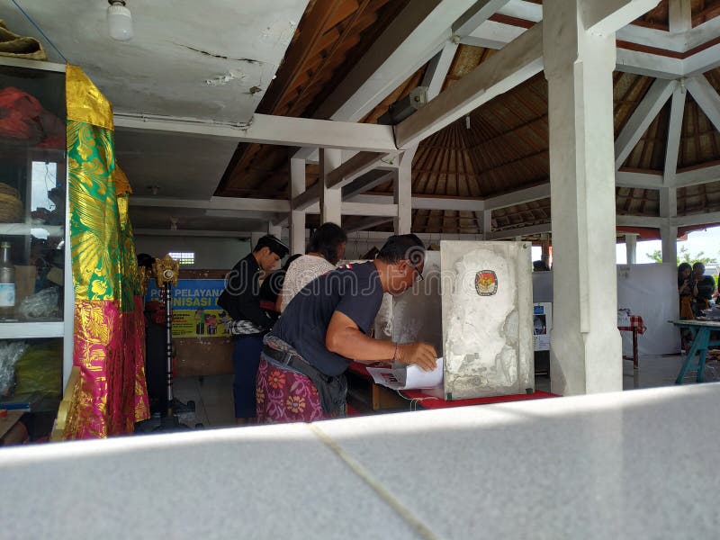 BALI/INDONESIA- 17 APRILE 2019: Voto della gente di balinese per il presidente ed il Parlamento 2019 Vanno a usando dei seggi ele immagine stock BALI/INDONESIA- 17 APRILE 2019: Voto della gente di balinese per il presidente ed il Parlamento 2019 Vanno a usando dei seggi ele immagine stock