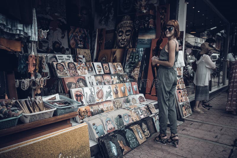 BALI, INDONESIA - 1 DE ENERO DE 2017: Mujer joven en la calle del recuerdo de Ubud, Bali, Indonesia imágenes de archivo libres de regalías BALI, INDONESIA - 1 DE ENERO DE 2017: Mujer joven en la calle del recuerdo de Ubud, Bali, Indonesia imágenes de archivo libres de regalías