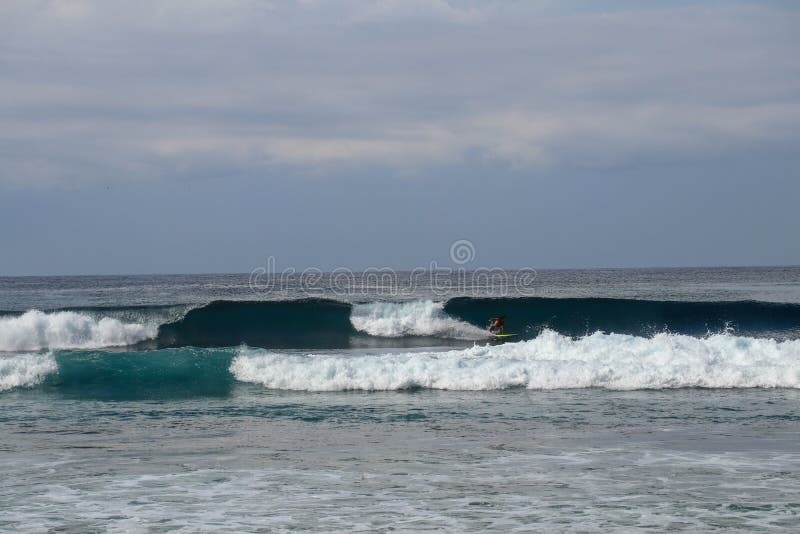 Bali, Indonesia. Surfer ride on barrel wave. Surfer on yellow surfboard in the ocean on a sunny day. Extreme pro sportsman surfing royalty free stock image Bali, Indonesia. Surfer ride on barrel wave. Surfer on yellow surfboard in the ocean on a sunny day. Extreme pro sportsman surfing royalty free stock image