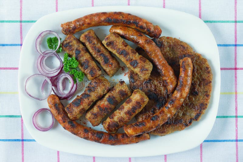 Balkan kokkonst Cevapi, kobasica och pljeskavica - grillad maträtt av köttfärs Lekmanna- lägenhet arkivbilder Balkan kokkonst Cevapi, kobasica och pljeskavica - grillad maträtt av köttfärs Lekmanna- lägenhet arkivbilder