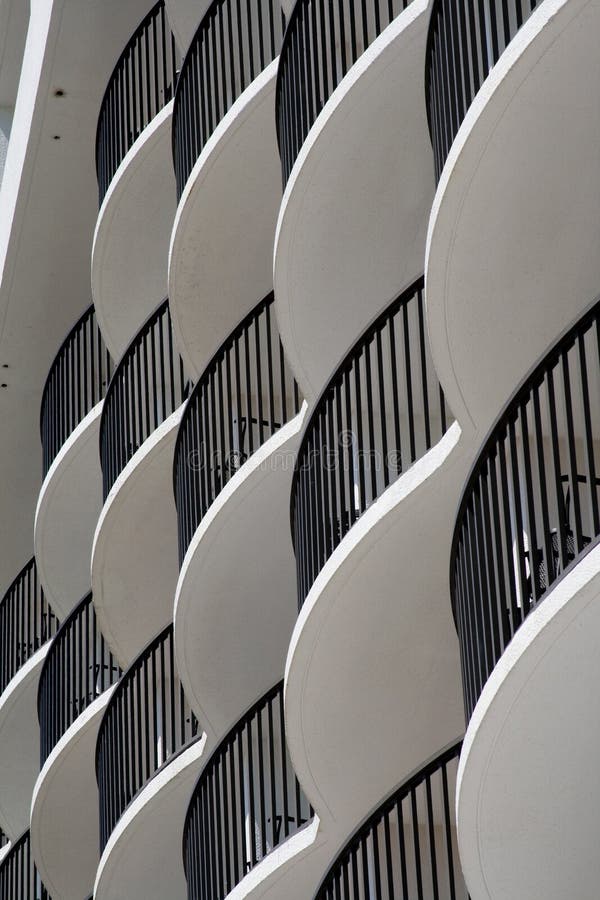 Curved white hotel balconies with black iron railings. Curved white hotel balconies with black iron railings