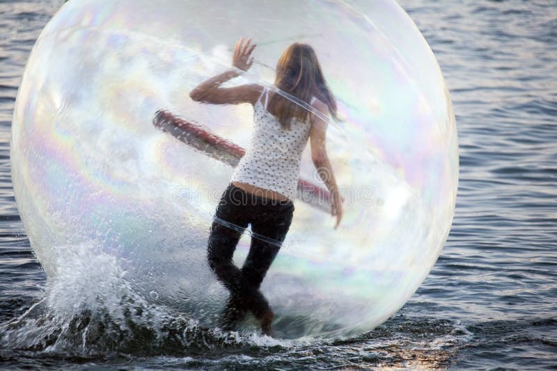 Ballando su una ragazza dell'acqua all'interno della sfera di plastica fotografie stock libere da diritti Ballando su una ragazza dell'acqua all'interno della sfera di plastica fotografie stock libere da diritti