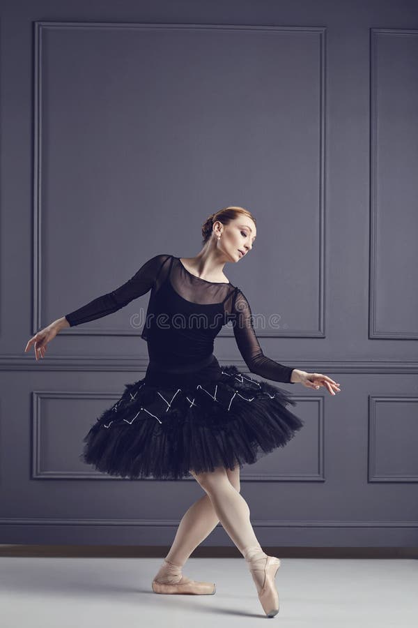 Ballerina in het zwarte tutu stellen op een zwarte achtergrond stock afbeelding Ballerina in het zwarte tutu stellen op een zwarte achtergrond stock afbeelding