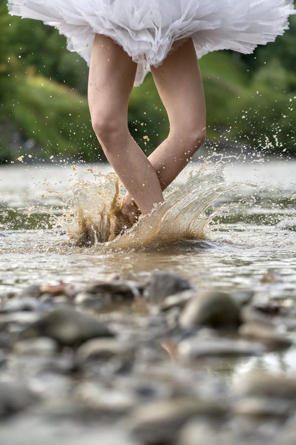 Ballerina jumping in river