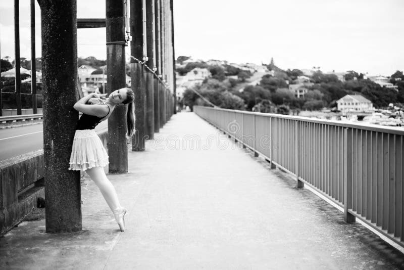 Ballerina leaning against bridge pillar