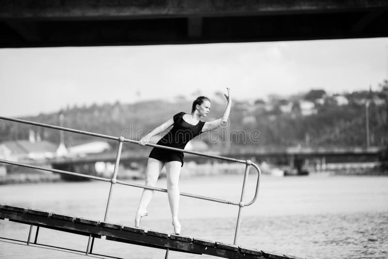 Ballerina leaning through a bridge railing