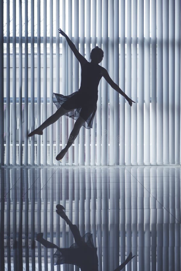 Ballerino di balletto grazioso che salta vicino alla finestra