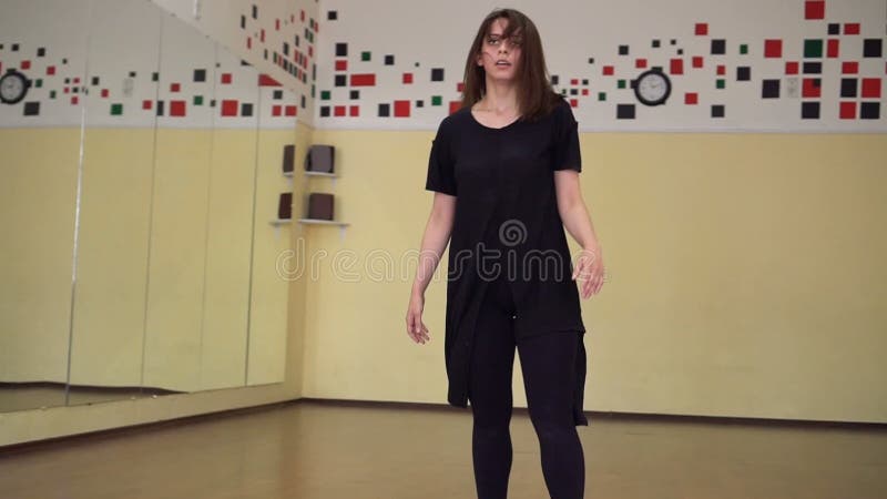 Ballerino moderno che riscalda in uno studio con gli specchi Ballo di formazione della ragazza