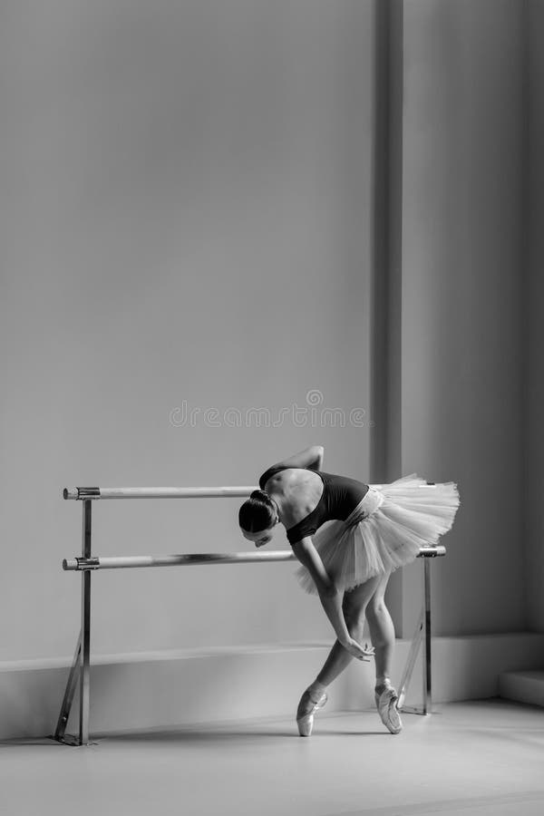 Beautiful ballerina training in the class. Ballet class. Dancer doing exercises at handrail.