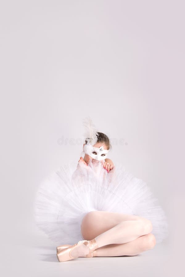 Ballet dancer in a white tutu and a carnival mask
