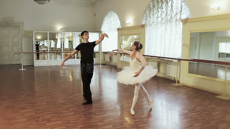 Ballet de danse de jeune homme et de femme agée synchroniquement dans le gymnase