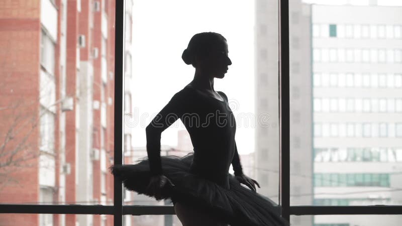 Balletto sullo sfondo dell'edificio urbano Silhouette ballerina fa un bel movimento