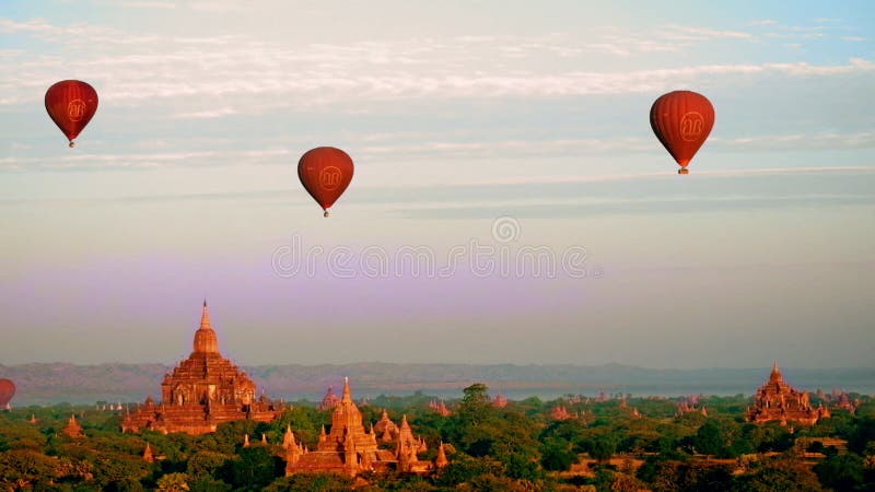 Ballonger för varm luft som flyger på soluppgång över forntida buddistiska tempel på Bagan myanmar