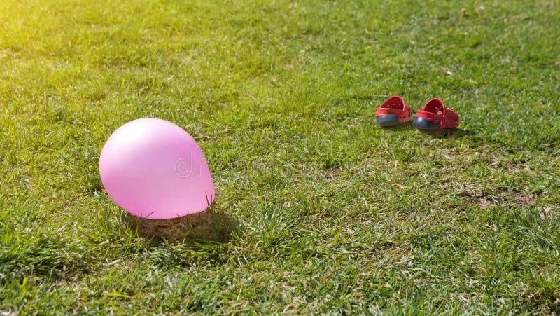 Balloon and children's sandals on green grass royalty free stock image Balloon and children's sandals on green grass royalty free stock image