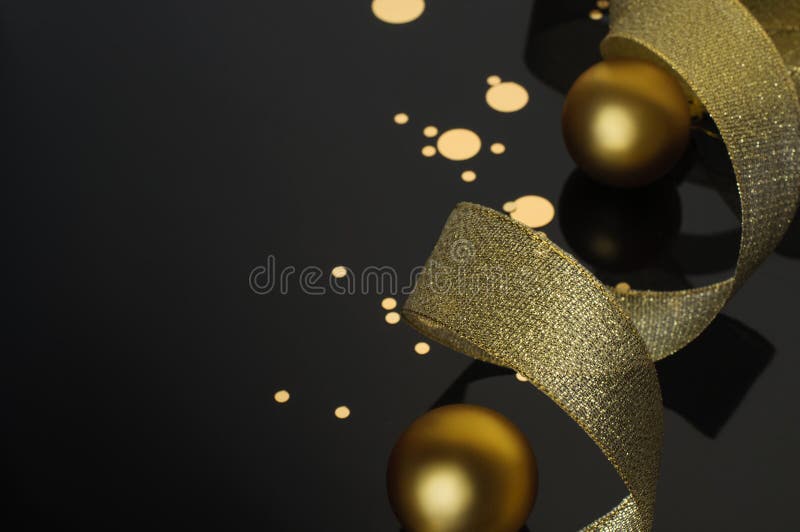Baloane aurii cu panglică lucioasă și confetti aurii pe fond negru stock image