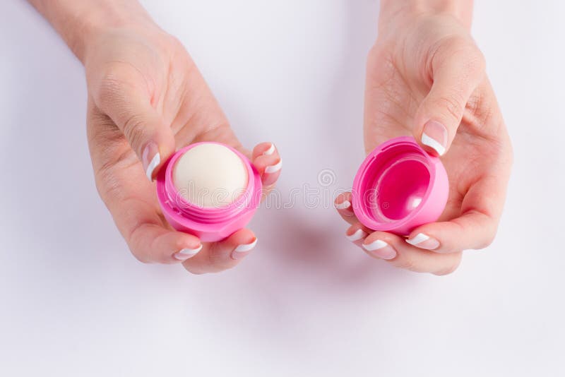 Balsamo di labbro rosa in belle dita femminili fotografia stock libera da diritti Balsamo di labbro rosa in belle dita femminili fotografia stock libera da diritti