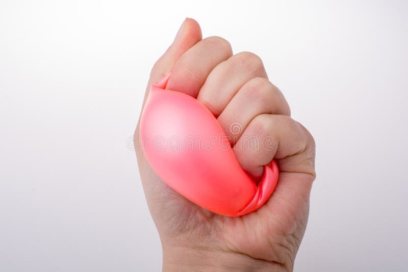 A apertar um balão rosa com a mão foto de stock royalty free