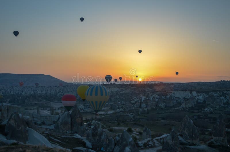 Balões de ar quente de Sunrice que aterram em uma montanha Cappadocia Goreme imagens de stock royalty free Balões de ar quente de Sunrice que aterram em uma montanha Cappadocia Goreme imagens de stock royalty free
